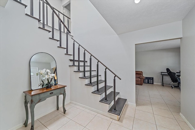 staircase with light tile floors and a textured ceiling