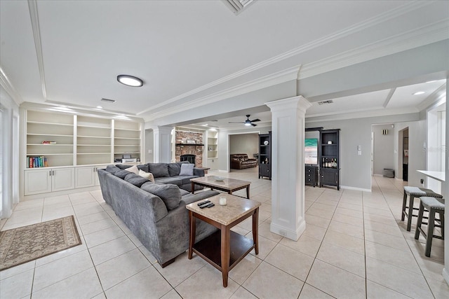 living room with crown molding, built in features, ceiling fan, and ornate columns