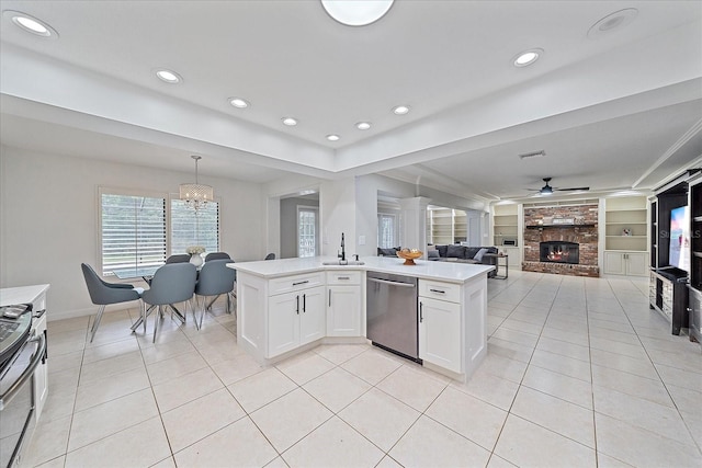 kitchen featuring decorative light fixtures, a fireplace, ceiling fan with notable chandelier, appliances with stainless steel finishes, and built in features