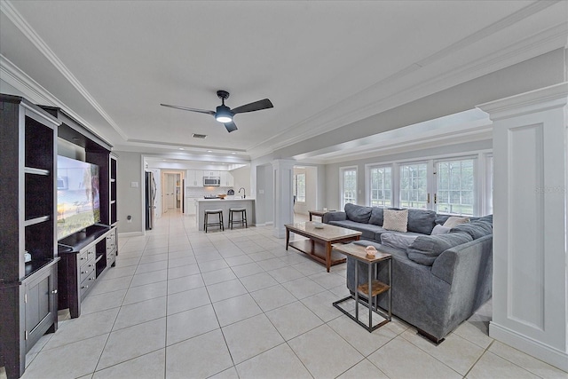 tiled living room featuring ceiling fan, decorative columns, ornamental molding, and french doors