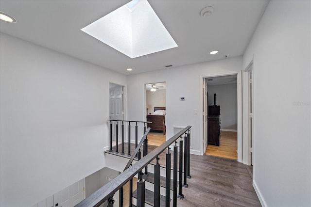 hallway featuring a skylight and dark hardwood / wood-style floors