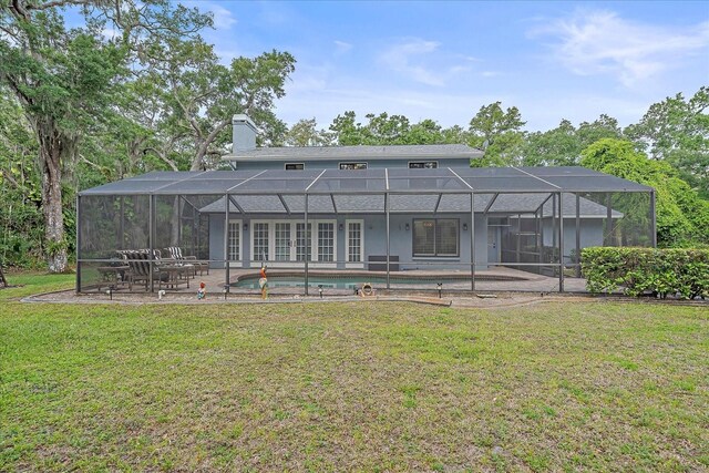 back of house featuring a lanai, a patio, and a lawn