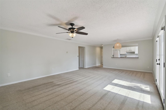 carpeted empty room with ceiling fan, crown molding, and a textured ceiling