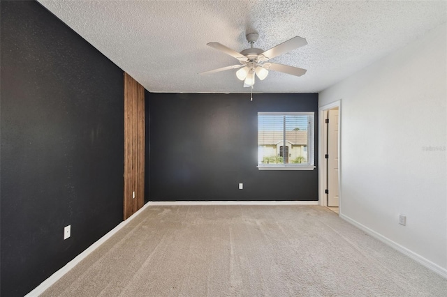 spare room featuring ceiling fan, a textured ceiling, and light colored carpet