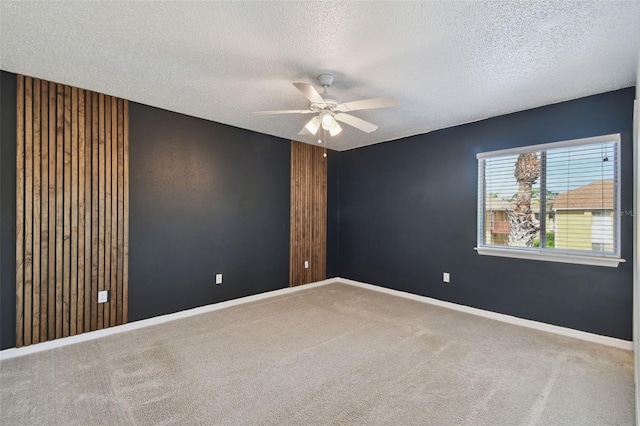 unfurnished room with ceiling fan, carpet floors, and a textured ceiling