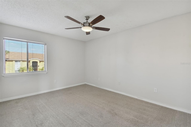 empty room featuring ceiling fan, a textured ceiling, and carpet flooring