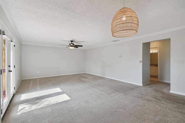 carpeted empty room featuring ceiling fan, a textured ceiling, and ornamental molding