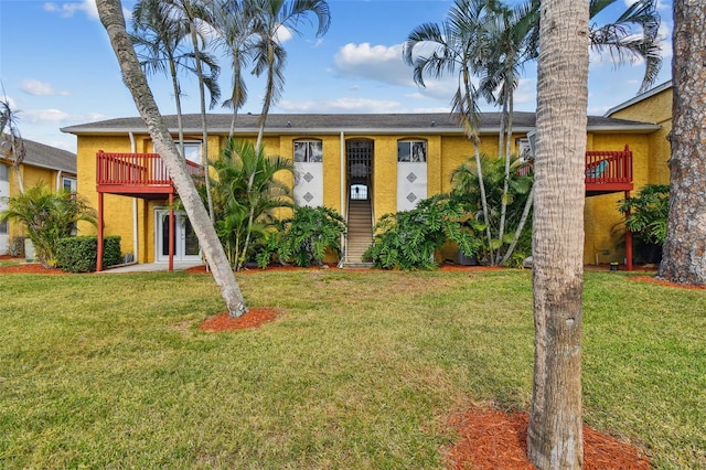 view of front of home featuring a balcony and a front yard