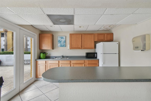 kitchen with white fridge, a paneled ceiling, and plenty of natural light