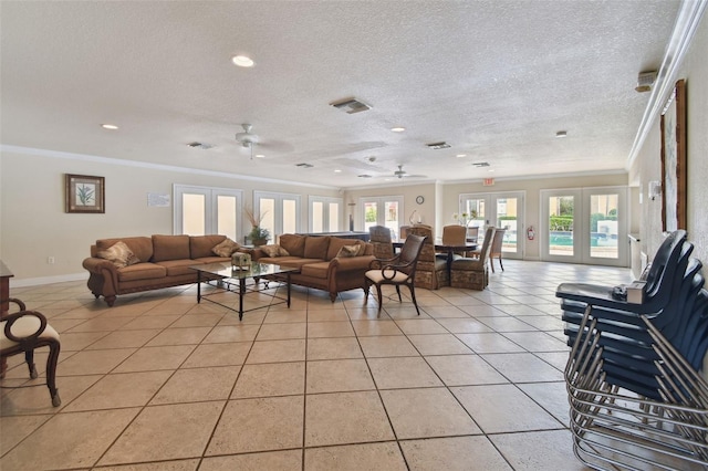 tiled living room with crown molding, ceiling fan, and french doors