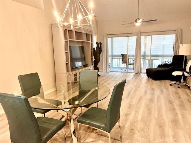 dining space featuring light hardwood / wood-style floors and ceiling fan with notable chandelier