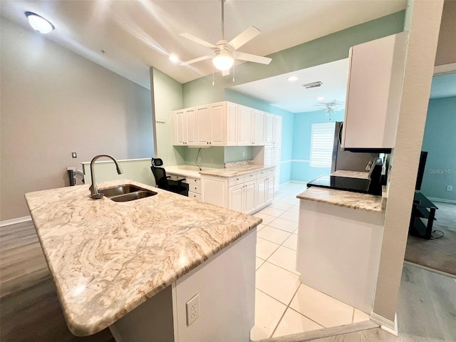 kitchen featuring white cabinets, light tile flooring, kitchen peninsula, sink, and ceiling fan