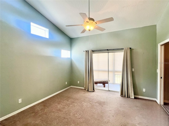 carpeted spare room featuring ceiling fan and vaulted ceiling