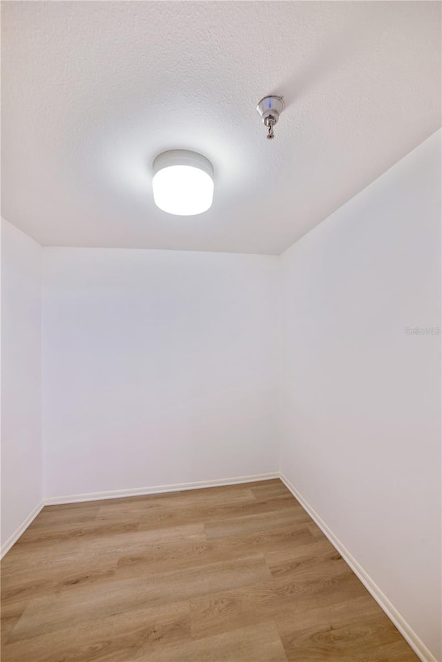 spare room featuring hardwood / wood-style floors and a textured ceiling