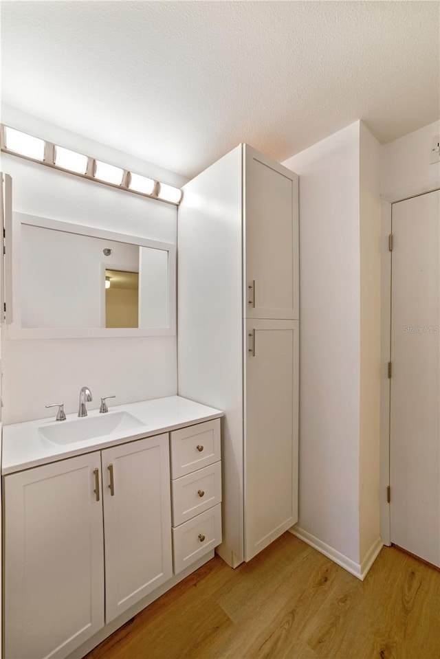 bathroom featuring a textured ceiling, wood finished floors, and vanity