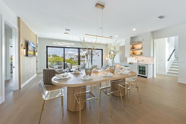 dining area with light wood-type flooring and wine cooler