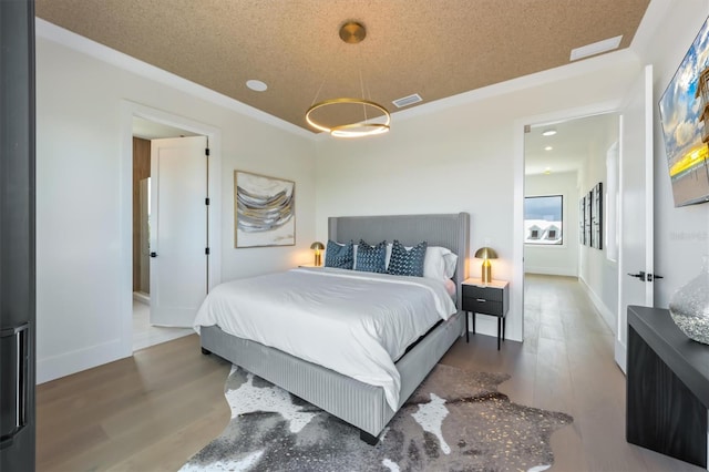 bedroom featuring hardwood / wood-style floors and a textured ceiling