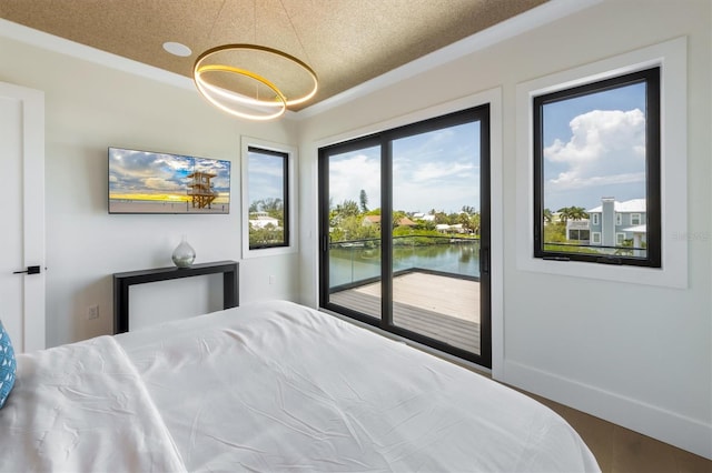 bedroom with a water view, access to exterior, and multiple windows