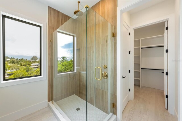 bathroom featuring wood-type flooring and a shower with shower door