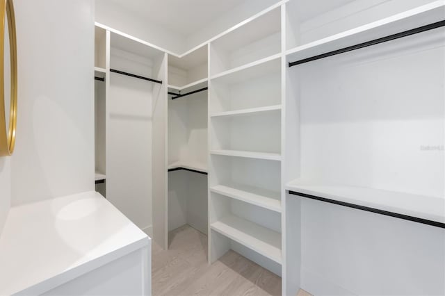 spacious closet with light hardwood / wood-style floors