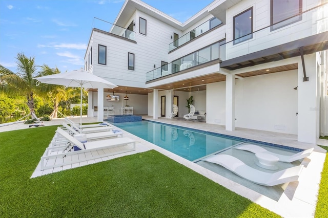 view of pool with a lawn and a patio