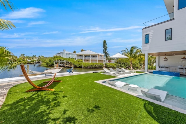 view of pool featuring a water view, a yard, a patio area, and a boat dock