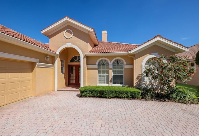 mediterranean / spanish house featuring french doors and a garage