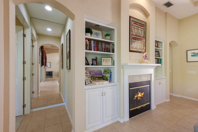 interior space featuring light tile flooring and built in shelves