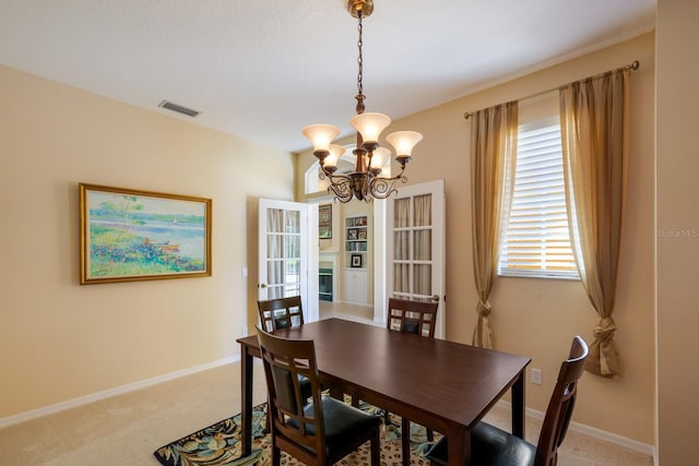 dining area with carpet and an inviting chandelier