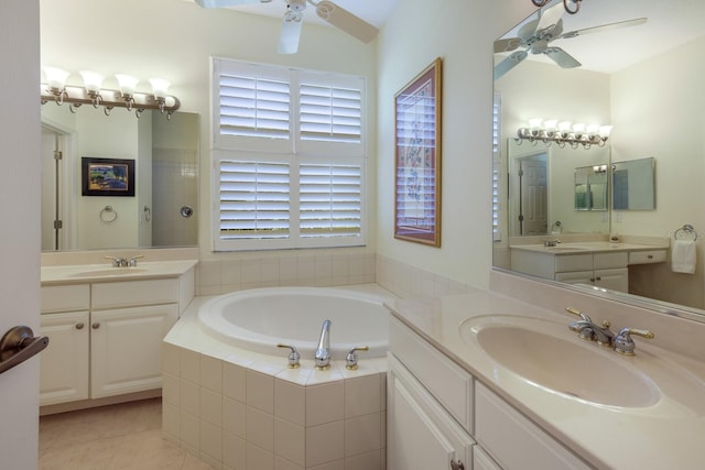 bathroom with tiled tub, double vanity, tile flooring, and ceiling fan