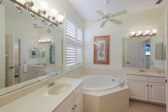 bathroom with tile flooring, ceiling fan, large vanity, a relaxing tiled bath, and double sink