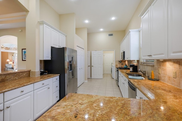 kitchen with tasteful backsplash, stainless steel appliances, sink, and white cabinetry