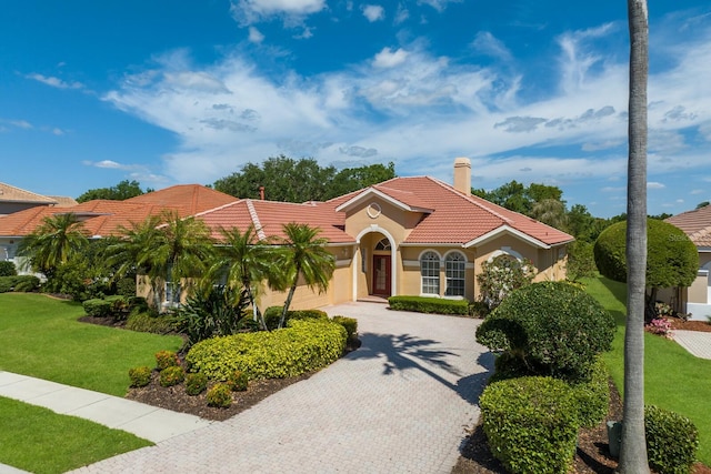 mediterranean / spanish home with a front lawn