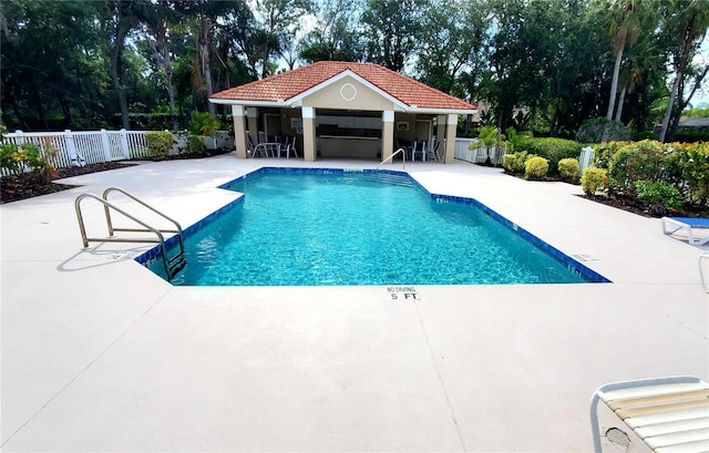 view of swimming pool with a patio area and exterior bar