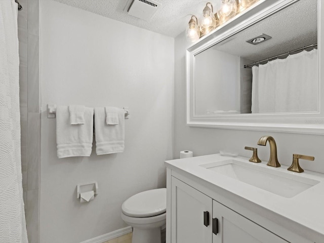 bathroom featuring a textured ceiling, toilet, and vanity