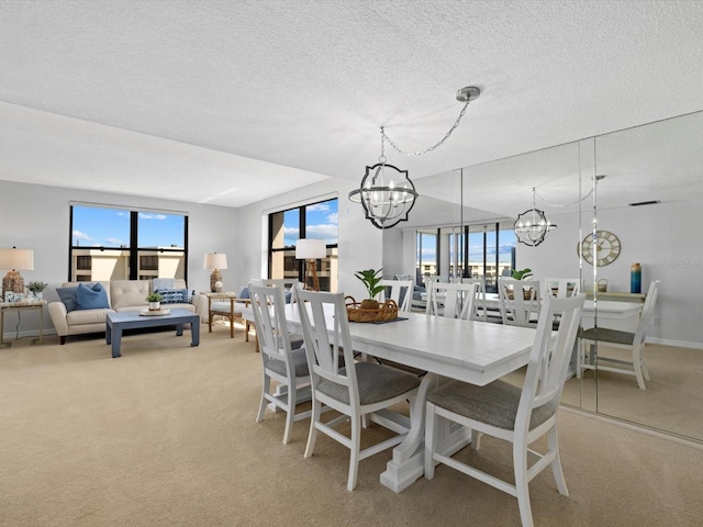 carpeted dining area with plenty of natural light, a textured ceiling, and a chandelier