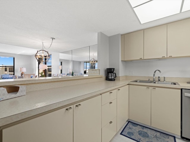 kitchen with stainless steel dishwasher, light tile flooring, sink, a chandelier, and cream cabinets