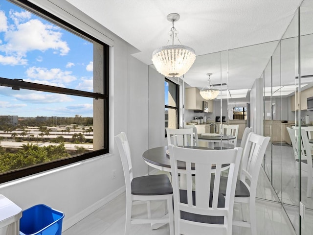 dining space with a chandelier, a textured ceiling, and light tile floors