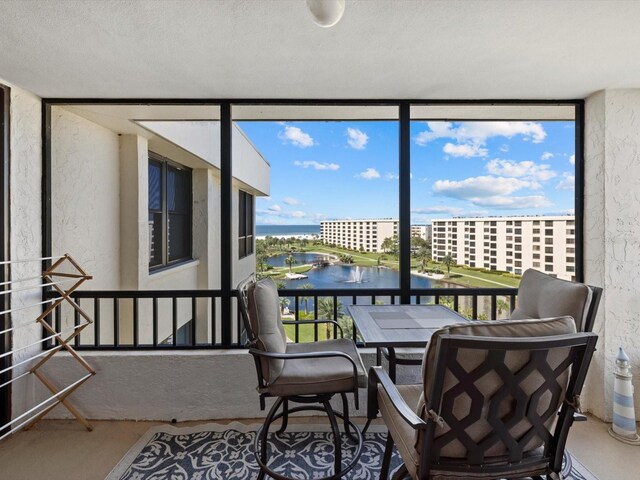 sunroom featuring a water view