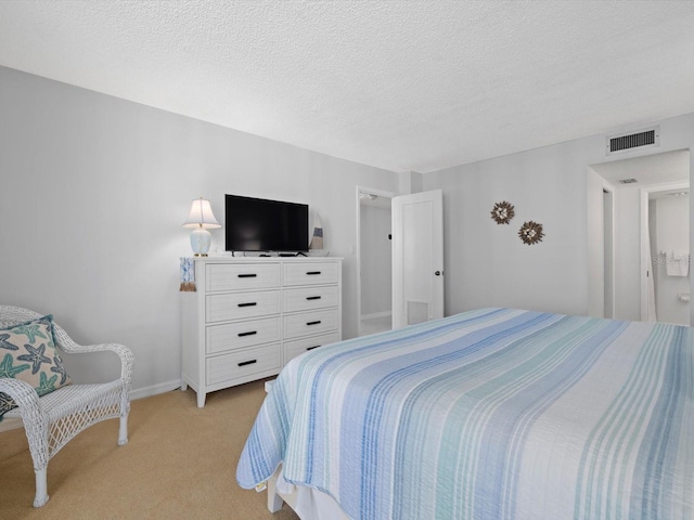 bedroom featuring light colored carpet and a textured ceiling