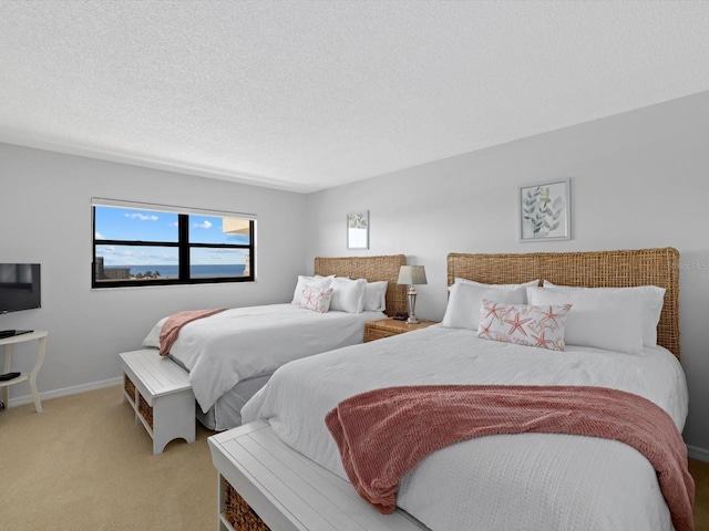 bedroom with a textured ceiling and light colored carpet