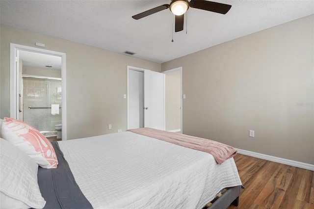 bedroom with connected bathroom, a textured ceiling, ceiling fan, and dark wood-type flooring