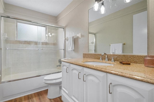 full bathroom with toilet, combined bath / shower with glass door, vanity, and wood-type flooring