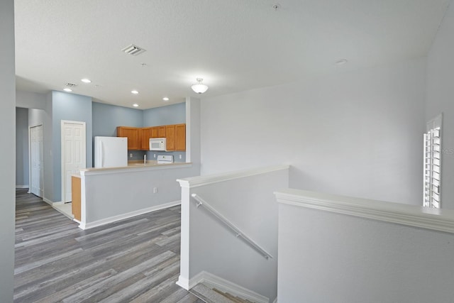 interior space featuring a textured ceiling and wood-type flooring