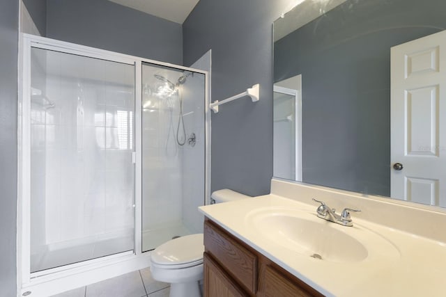 bathroom with toilet, vanity, tile patterned floors, and a shower with shower door