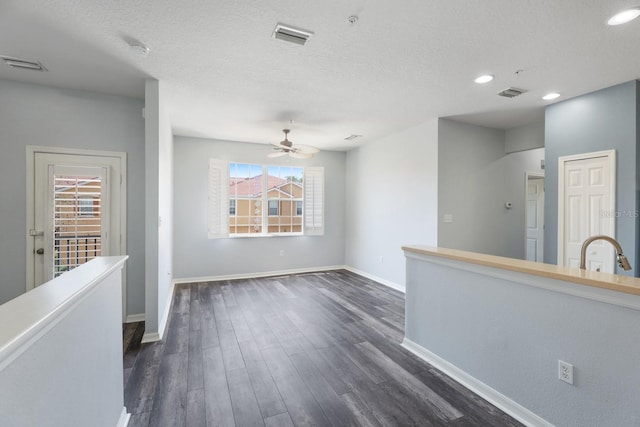 interior space with ceiling fan, plenty of natural light, dark hardwood / wood-style flooring, and a textured ceiling