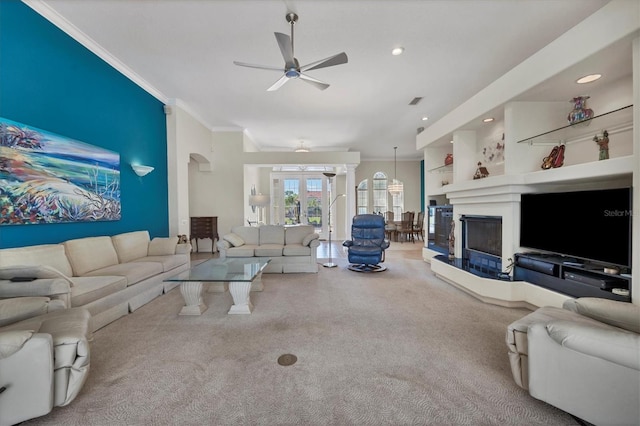 living room featuring carpet, ceiling fan, and crown molding