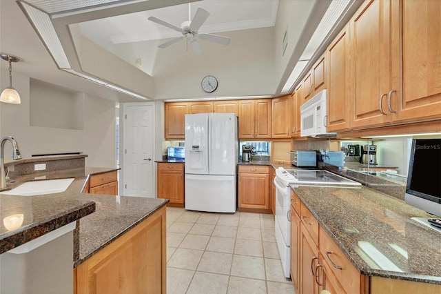 kitchen with pendant lighting, white appliances, sink, dark stone countertops, and light tile patterned floors