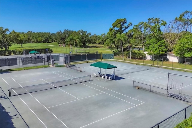 view of sport court featuring a lawn