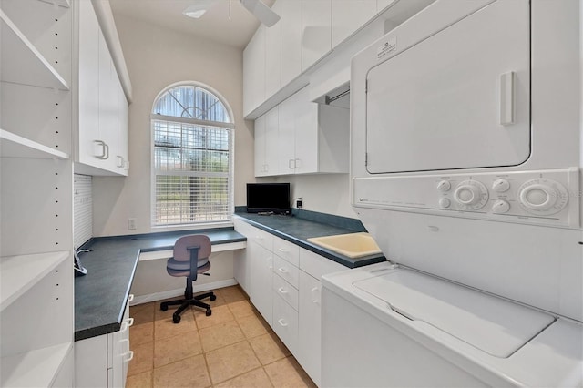 laundry room with ceiling fan, light tile patterned floors, cabinets, and stacked washer / drying machine